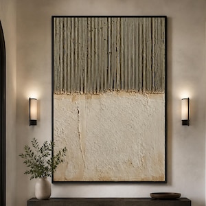 May include: A large rectangular wall art piece featuring a two-tone design. The top half consists of vertical, ribbed, tan-coloured texture, while the bottom half displays a smooth, off-white, plaster-like surface, all enclosed in a thin black frame.