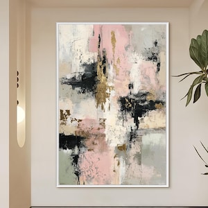 May include: Abstract art painting in a white frame. The artwork features a textured composition of pink, black, gold, and neutral tones. The brushstrokes create a dynamic and modern aesthetic, suitable for home decor.