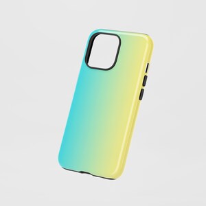 Puede incluir: Funda de teléfono con degradado azul y amarillo. La funda tiene un acabado brillante y un borde negro alrededor de la cámara. Se ven botones negros en el lateral.