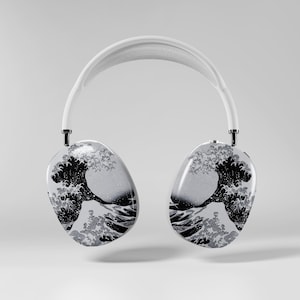 Könnte beinhalten: Weiße Over-Ear-Kopfhörer mit einem schwarz-weißen Wellenmuster, inspiriert von japanischer Kunst. Die Ohrmuscheln haben eine glänzende Oberfläche, und das Kopfband ist weiß.