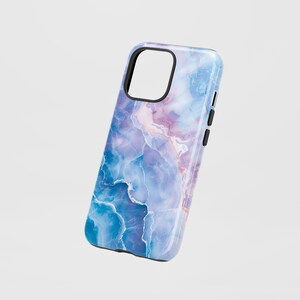 Könnte beinhalten: Smartphone-Hülle mit Marmormuster. Die Hülle hat eine Mischung aus blauen, violetten und weißen Farben mit einem schwarzen Rahmen um die Kamera und die Tasten. Die Hülle hat eine glänzende Oberfläche.