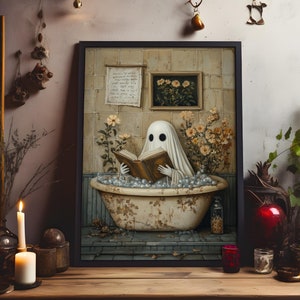 May include: A framed illustration of a ghost reading a book in a bathtub filled with bubbles. The ghost is white and has two black eyes. The bathtub is old and has a floral pattern. The background is a tiled bathroom with a floral wallpaper.