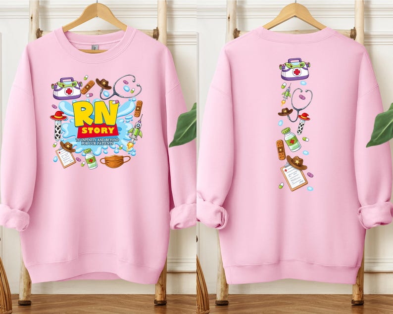 K&ouml;nnte beinhalten: Ein hellrosa Sweatshirt mit einem farbenfrohen Grafikdesign auf der Vorder- und R&uuml;ckseite. Die Grafik auf der Vorderseite zeigt "RN STORY" mit medizinischen Illustrationen. Die R&uuml;ckseite zeigt eine vertikale Anordnung &auml;hnlicher medizinischer Illustrationen.