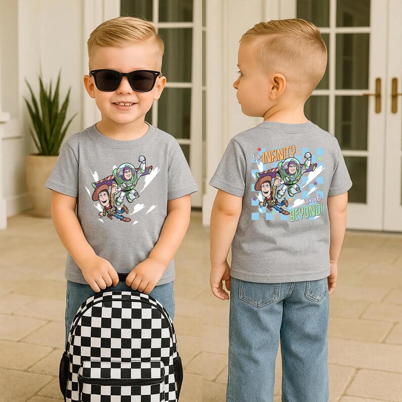 Puede incluir: Un ni&ntilde;o peque&ntilde;o con una camiseta gris con un dise&ntilde;o de Toy Story en la parte delantera y trasera. La parte delantera de la camiseta presenta a Woody y Buzz Lightyear. La parte trasera de la camiseta dice "To Infinity and Beyond!". El ni&ntilde;o tambi&eacute;n lleva gafas de sol y una mochila a cuadros en blanco y negro.