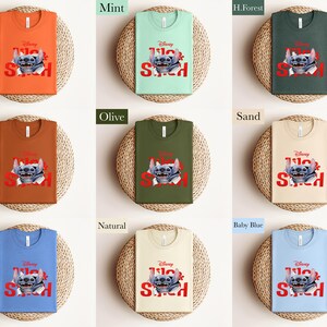 Puede incluir: Nueve camisetas de diferentes colores, cada una con un gr&aacute;fico de Stitch. Las camisetas son de varios colores, incluyendo naranja, menta y oliva. El gr&aacute;fico presenta a Stitch con las palabras "Lilo & Stitch" en rojo.