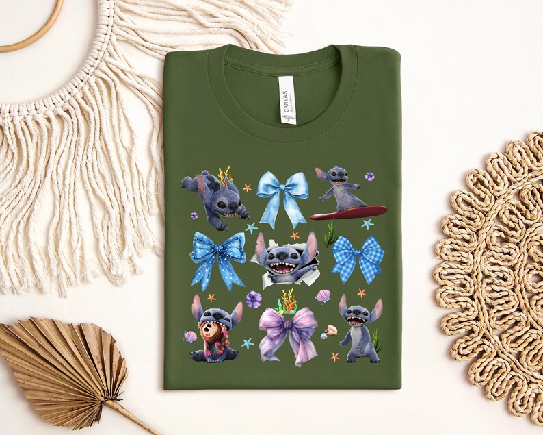 Puede incluir: Una camiseta verde oliva con un gr&aacute;fico colorido del personaje Stitch de Lilo & Stitch. El dise&ntilde;o incluye a Stitch en varias poses, rodeado de lazos azules y morados, conchas marinas y estrellas de mar. La camiseta tiene cuello redondo y una etiqueta.
