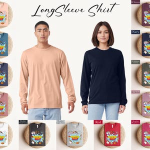 K&ouml;nnte beinhalten: Gezeigt werden verschiedene lang&auml;rmlige T-Shirts in verschiedenen Farben, darunter Pfirsich, Marineblau und Rot. Jedes Shirt hat eine Grafik mit dem Text "Nurse Story" und Cartoon-Figuren. Die Shirts werden auf gewebten Matten pr&auml;sentiert.