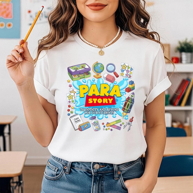 K&ouml;nnte beinhalten: Wei&szlig;es T-Shirt mit einem farbenfrohen Grafikdesign mit den Worten "PARA STORY" in Gelb und Rot, umgeben von Illustrationen zum Thema Schule. Das Design umfasst einen Globus, eine Lupe und eine Rakete.
