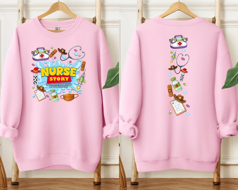 K&ouml;nnte beinhalten: Ein hellrosa Sweatshirt mit einem Cartoon-Design. Auf der Vorderseite stehen die Worte "Nurse Story" mit medizinischen Illustrationen. Die R&uuml;ckseite hat eine vertikale Anordnung &auml;hnlicher medizinischer Grafiken. Das Sweatshirt h&auml;ngt an einem Holzgestell.