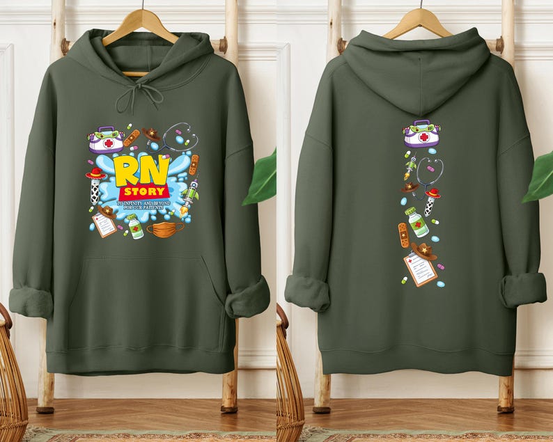 K&ouml;nnte beinhalten: Ein olivgr&uuml;ner Kapuzenpullover mit einem Front-Grafik-Design mit dem Text "RN STORY" in Gelb und Rot, umgeben von medizinischen Illustrationen. Die R&uuml;ckseite des Hoodies hat ein vertikales Design mit medizinischen Symbolen.