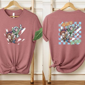 Puede incluir: Camiseta rosa polvoriento con un gr&aacute;fico de Woody, Buzz Lightyear y el texto "to infinity and beyond!". La parte delantera de la camiseta muestra a los personajes en vuelo. La parte trasera de la camiseta tiene el mismo gr&aacute;fico con un fondo a cuadros.