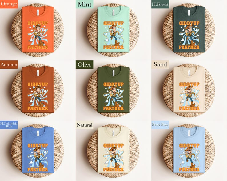 May include: A collection of t-shirts in various colors, each featuring a cartoon cowboy graphic with the text "GIDDYUP PARTNER". Colors include orange, mint, forest green, autumn, olive, sand, blue, natural, and baby blue.