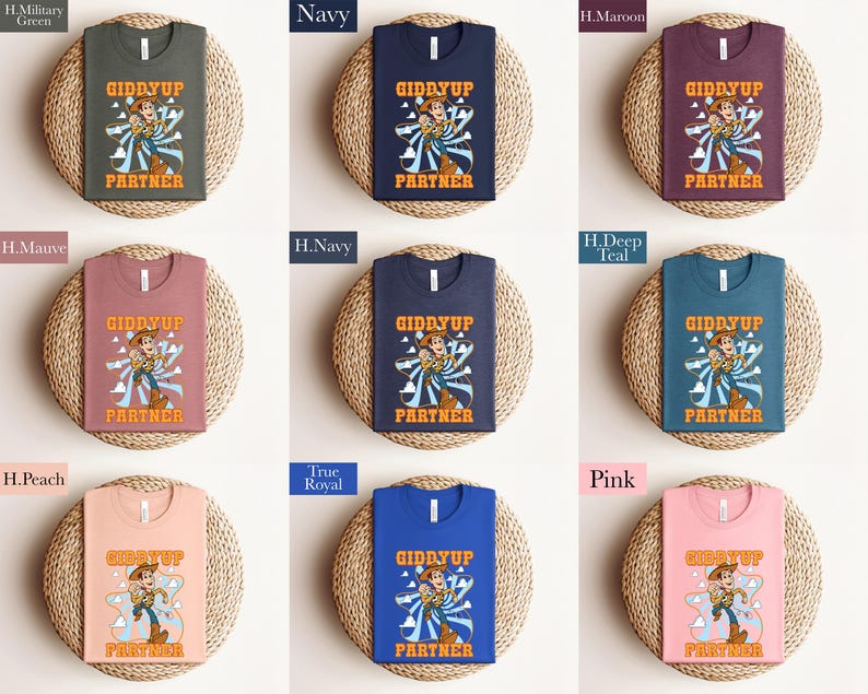 May include: A collection of t-shirts in various colors, each featuring a graphic of a cartoon cowboy with the text "GIDDYUP PARTNER". The shirts are displayed on round woven mats, showcasing a range of hues including green, navy, maroon, and pink.