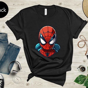 May include: Black t-shirt featuring a cartoon illustration of Spider-Man's head and shoulders. The superhero's mask is red with white eyes and blue accents. The word "Black" is in a black circle in the upper left corner.
