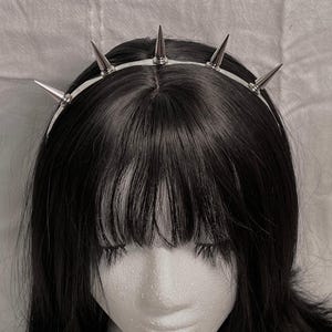 May include: Silver headband with pointed spikes, worn on a mannequin with black hair.