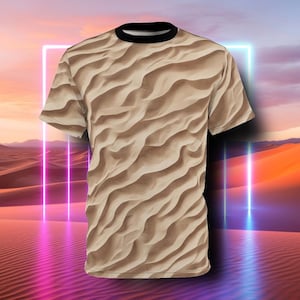 Op de afbeelding: Een beige T-shirt met een zandduinpatroon. Het shirt heeft korte mouwen en een ronde hals.