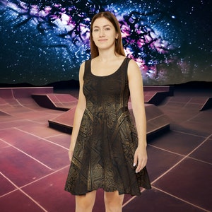 May include: A black skater dress with a gold geometric pattern. The dress is sleeveless and has a scoop neck. The model is standing in front of a skate park with a starry night sky in the background.
