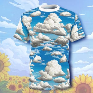 Könnte beinhalten: Ein kurzärmeliges T-Shirt mit einem Design aus blauem Himmel und weißen Wolken. Das T-Shirt hat einen weißen Kragen. Der Hintergrund zeigt einen pixeligen blauen Himmel und Sonnenblumen.