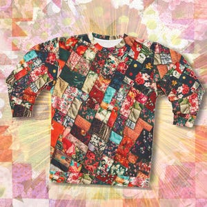 Op de afbeelding: Een sweatshirt met lange mouwen met een patchwork-ontwerp met verschillende bloemenpatronen in tinten rood, roze, blauw en groen.