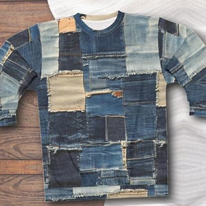 Könnte beinhalten: Ein langärmliges Shirt mit Patchwork-Design aus verschiedenen Blautönen von Denim. Das Shirt hat einen Rundhalsausschnitt und ist aus einem weichen, bequemen Stoff gefertigt.
