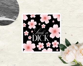 Può includere: Un adesivo quadrato con sfondo nero caratterizzato da un motivo di fiori di ciliegio rosa chiaro e dal testo bianco "Suck a DICK" stampato al centro. L'adesivo presenta un bordo bianco e una finitura opaca liscia sulla sua superficie.