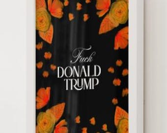 Può includere: Stampa artistica incorniciata con sfondo nero e accenti floreali arancioni. Il testo "Fuck DONALD TRUMP" è visualizzato in scrittura bianca. La stampa è racchiusa in una cornice bianca e montata su una parete bianca.