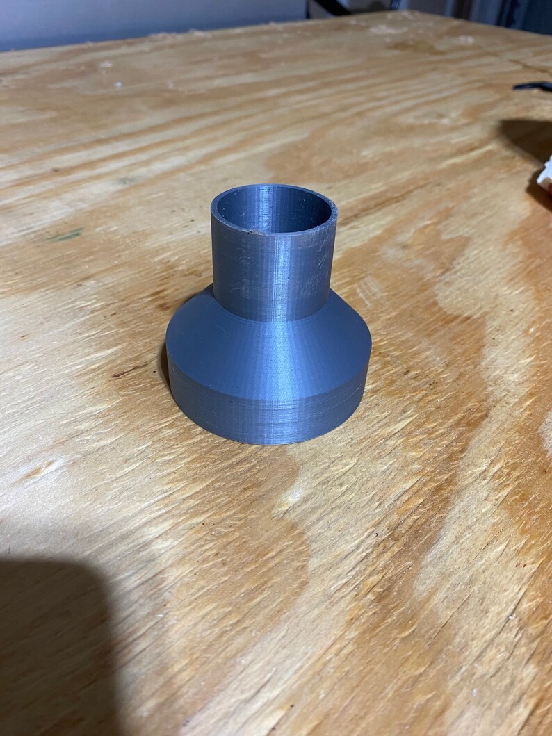 May include: A grey plastic 3D printed funnel with a wide base and a narrow opening.