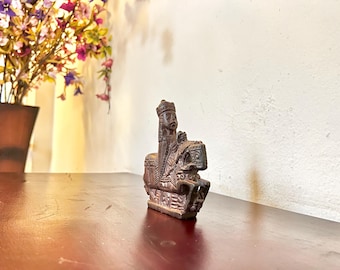 Könnte beinhalten: Eine dunkelbraune, geschnitzte Holzfigur einer Person, die ein Pferd reitet. Die Figur ist detailliert mit einer Krone und aufwendiger Kleidung. Die Skulptur steht auf einem rechteckigen Sockel und ist wahrscheinlich ein Dekorationsartikel.