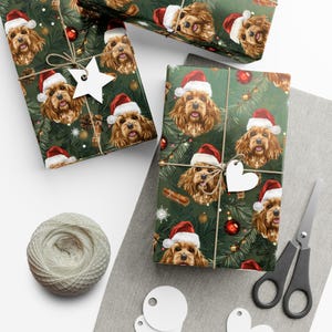 May include: Christmas-themed wrapping paper featuring a repeating pattern of a dog wearing a Santa hat, set against a green background with festive elements. The wrapped gifts are tied with twine and adorned with star-shaped tags.