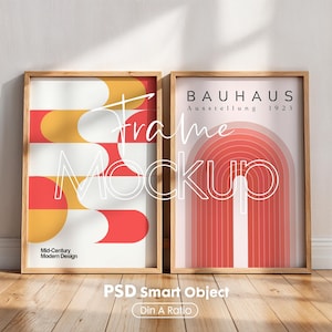 May include: Two framed prints with abstract geometric designs in shades of red and yellow. The left print has the text "Mid-Century Modern Design". The right print has the text "BAUHAUS Ausstellung 1923".