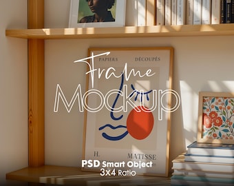 May include: A framed art print with a red circle and blue wave design. The print is on a shelf with books and other framed artwork. The text on the print reads "Papiers Découpés H. Matisse".