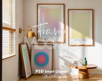 May include: A mockup featuring framed art prints with colorful abstract designs. The frames are wooden, and the prints have gradients of pink, yellow, and green. A small wooden side table holds books and a green vase. The text "Frame Mockup" is overlaid.