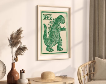 May include: A framed print of a green Godzilla-like monster with the Japanese word "Gojira" printed above it.