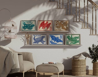 May include: Six framed prints of Japanese mythical creatures, each with a different creature and Japanese text. The prints are arranged in two rows of three on a white wall. The prints are in a variety of colors, including red, blue, green, and gold.