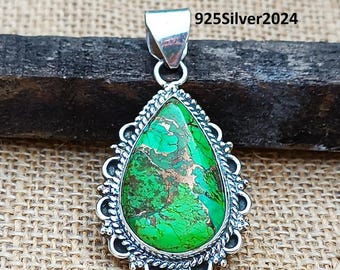 May include: A silver pendant with a green and gold turquoise stone set in a decorative silver frame. 925Silver2024 is printed on the image.