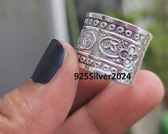 Könnte beinhalten: Ein silberner Ring mit aufwendigen floralen und geometrischen Mustern. Der Ring hat ein Banddesign mit geprägten Details, darunter Blumen und kreisförmige Akzente. Der Text "925Silver2024" ist auf der Oberfläche des Rings sichtbar.