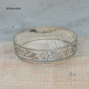 Può includere: Un braccialetto rigido in argento con un design floreale. Il braccialetto è realizzato in argento sterling 925 e presenta un delicato motivo floreale.