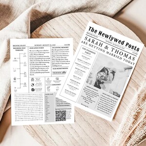 K&ouml;nnte beinhalten: Zwei schwarz-wei&szlig; Hochzeitszeitungsdrucke. Einer zeigt eine Zeitleiste und ein Wortsuchr&auml;tsel, der andere eine Schlagzeile mit der Aufschrift "SARAH & THOMAS HEIRATEN HEUTE". Die Drucke befinden sich auf einer Holzoberfl&auml;che mit dekorativen Elementen.