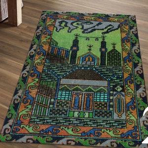 May include: A green and blue prayer rug with a mosque design. The rug has a traditional pattern with orange, yellow, and black accents.