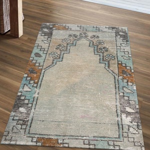 以下が含まれることがあります： 幾何学模様の入った薄い青と茶色のヴィンテージラグ。ラグは色あせていて、家にボヘミアンなスタイルを加えるのに最適です。