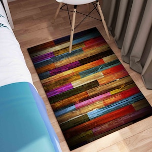 May include: A colorful rug with a wood plank design. The rug features a variety of colors, including red, orange, yellow, green, blue, purple, and brown. The rug is made of a soft, durable material and is perfect for adding a touch of color and style to any room.