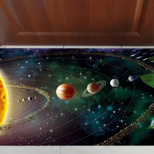 Puede incluir: Una colorida alfombra de bienvenida con una representación del sistema solar. El sol está en la esquina inferior izquierda, y los planetas están dispuestos en sus órbitas alrededor del sol. El fondo es azul oscuro con estrellas y una nebulosa verde.