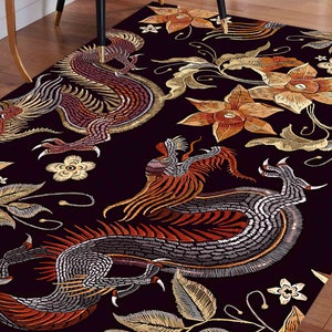 Può includere: Tappeto nero con un motivo ripetuto di draghi e fiori ricamati in oro e rosso.
