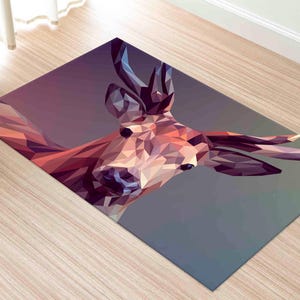 May include: Rectangular floor mat featuring a geometric design of a deer's head. The artwork uses a low-poly style with shades of purple, orange, and brown. The mat is placed on a light-colored wooden floor.