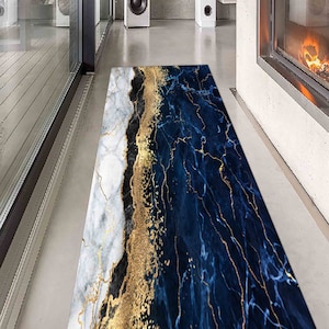 Op de afbeelding: Een blauwe en witte marmeren loper met gouden accenten. De loper heeft een modern ontwerp en is perfect om elke kamer een vleugje elegantie te geven.