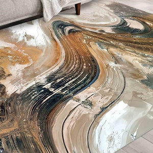 Puede incluir: Alfombra de área abstracta con patrones en espiral en tonos marrones, beige y negros. La alfombra tiene un diseño moderno y contemporáneo.