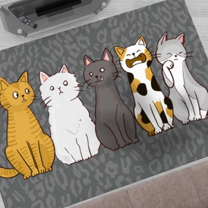 May include: A gray and white rug with a leopard print design features five cartoon cats in various poses. The cats are orange, white, gray, black, and calico.