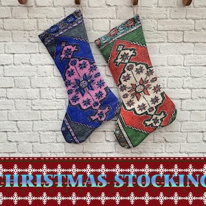 May include: Two Christmas stockings made from colorful patterned fabric. The stocking on the left is blue with pink and white accents. The stocking on the right is green with red and white accents.