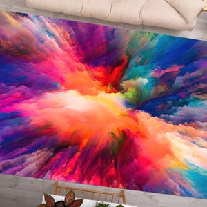 May include: Abstract art rug with a colorful explosion of pink, purple, blue, orange, and yellow hues. The rug has a vibrant and dynamic design.