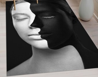 Pode incluir: Uma fotografia a preto e branco de um rosto, metade pintado de preto e metade pintado de branco. Os olhos da pessoa estão fechados.